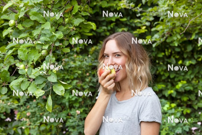 N2102073 Junge Frau isst einen Apfel