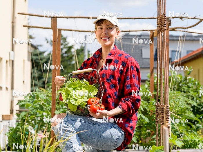 N2103255 Young woman in urban vegetable garden